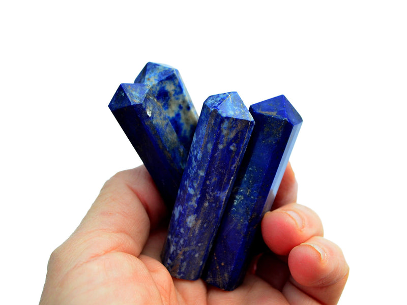 Four lapis lazuli crystal points 55mm-65mm on hand with white background