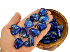 Ten blue lapis lazuli heart crystals 30mm-35mm on hand with background with some stones inside a woof bowl