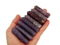 Nine purple lepidolite crystal points 50mm-55mm on hand with white background