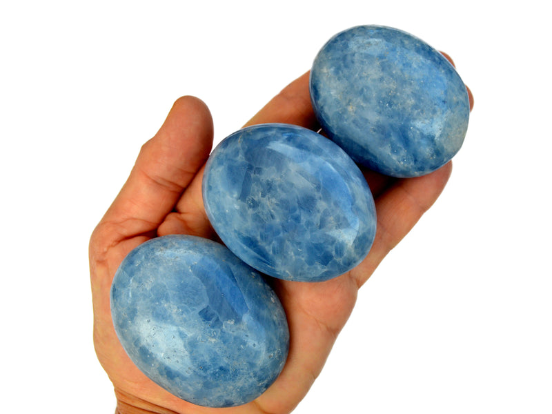 Three blue calcite palm stones 55mm on hand with white background