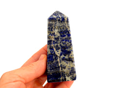 A lapis lazuli crystal obelisk 80mm on hand with white background