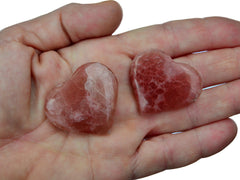 Twho rose calcite hearts 30mm-40mm on hand with white background