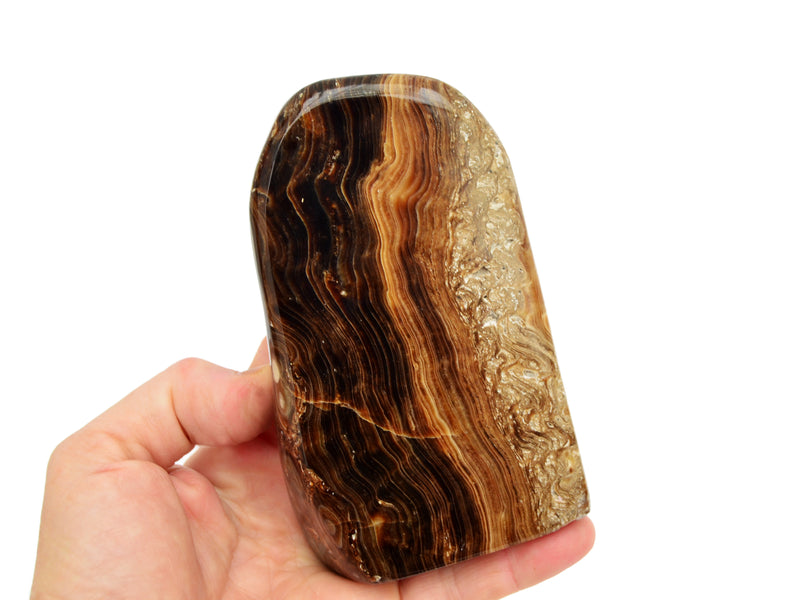 One chocolate calcite free form crystal 120mm on hand with white background