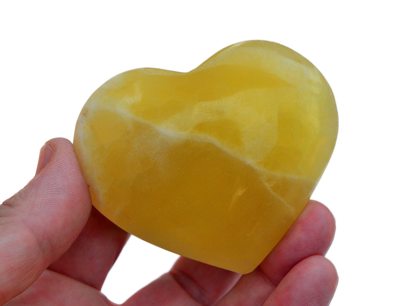 One lemon calcite heart shaped crystals 60mm on hand with white background