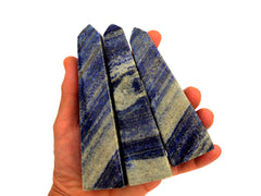 Three natural lapis lazuli obelisks 130mmon hand with white background
