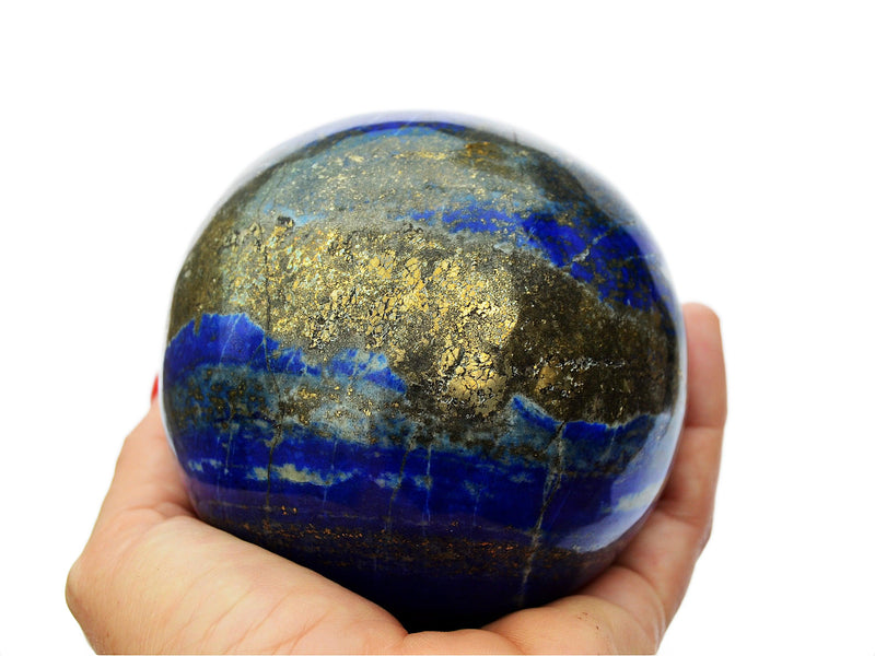 Large lapis lazuli sphere crystal 95mm on hand with white background