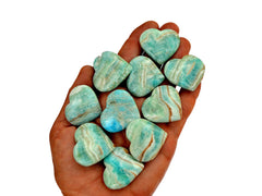 Ten small blue aragonite hearts 30mm-35mm on hand with white background