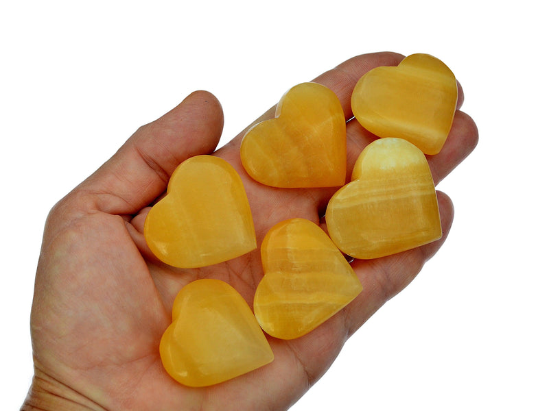 Six orange calcite hearts  35mm-40mm on hand with white background
