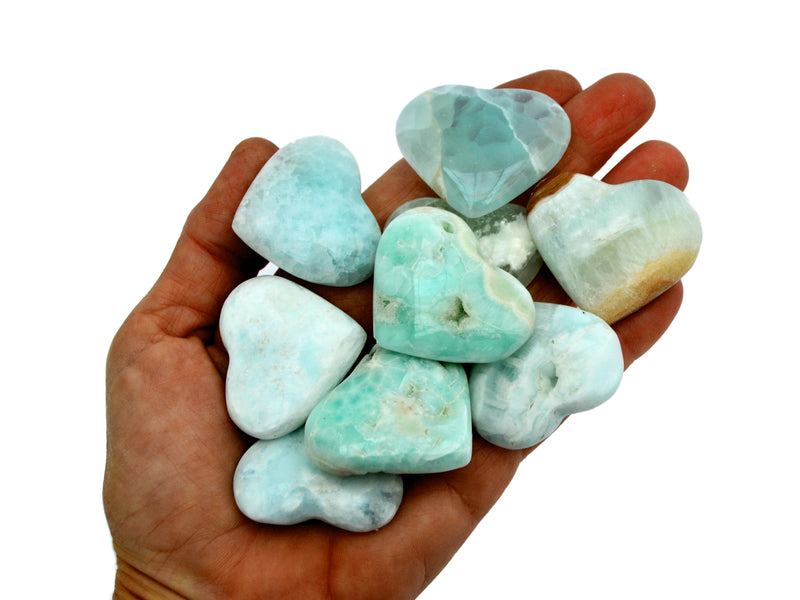 Some caribbean calcite small hearts 40mm on hand with white background