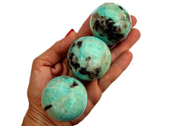 Three amazonite sphere sstones 55mm-60mm on hand with white background