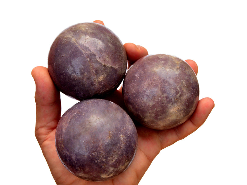 Three purple lepidolite spheres 60mm-65mm on hand with white background