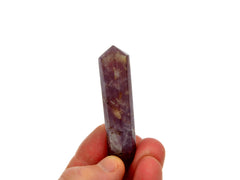 One purple lepidolite point 55mm on hand with white background