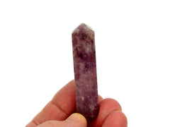 One purple lepidolite crystal point 55mm on hand with white background