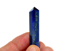 One royal blue lapis lazuli crystal point 50mm on hand with white background