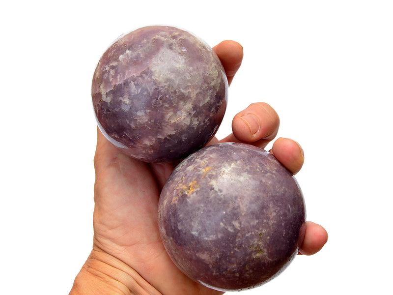 Two purple lepidolite crystal spheres 60mm-70mm on hand with white background