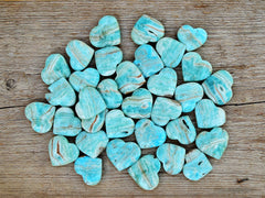 Several small blue aragonite heart shapped stones on wood table 