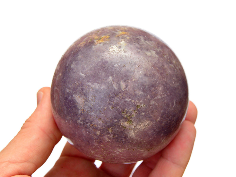 Large lepidolite crystal sphere 80mm on hand with white background