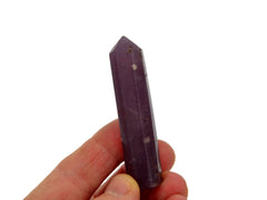 One purple lepidolite faceted crystal point 55mm on hand with white background