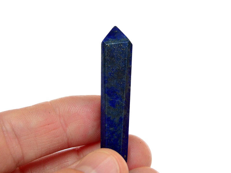 One blue lapis lazuli crystal point 40mm on hand with white background