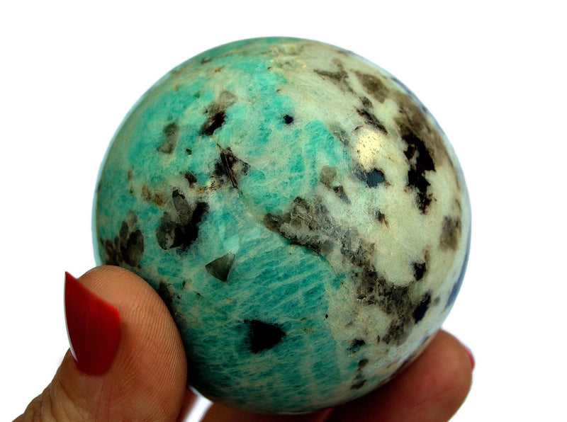 One amazonite crystal sphere 55mm on hand with white background