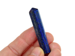 One blue lapis lazuli crystal point 45mm on hand with white background