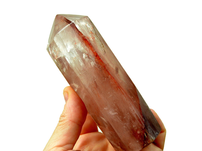 One large fire quartz obelisk crystal 110mm on hand with white background