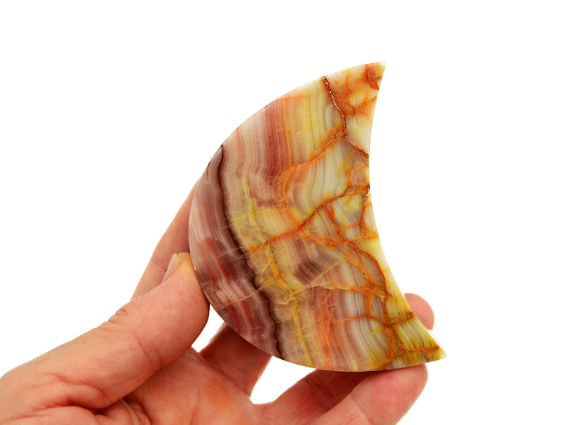 One pink banded onyx moon carved stone 80mm on hand with white background