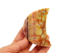 One pink banded onyx moon stone 80mm on hand with white background