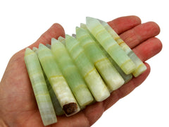Some green pistachio calcite points 65mm-70mm on hand with white background