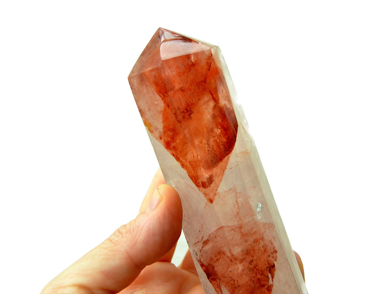 One chunky fire quartz obelisk crystal 110mm on hand with white background