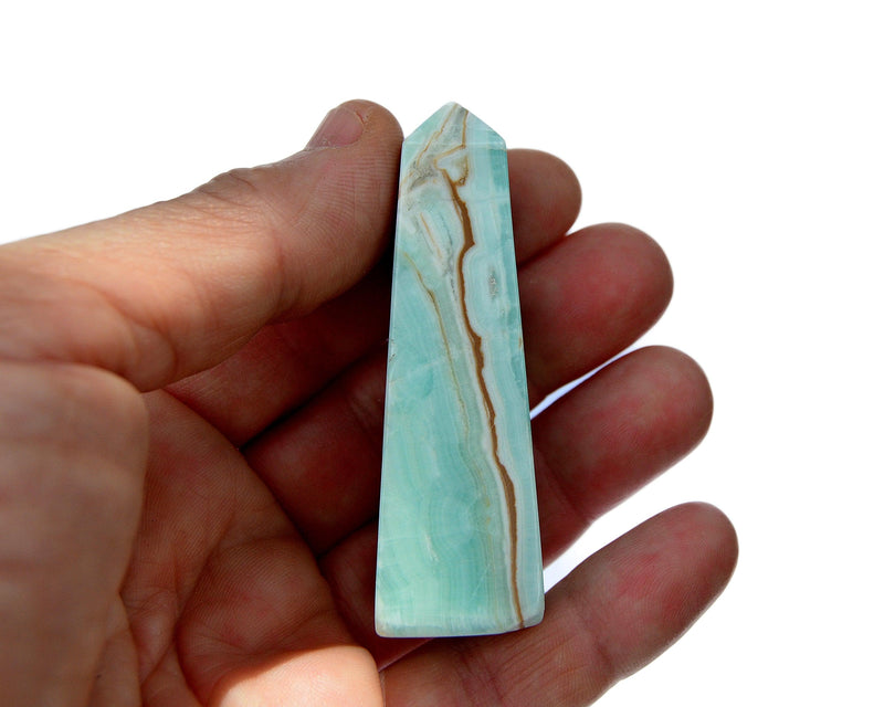 One blue aragonite crystal tower on hand with white background