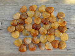 Several goldenhealer quartz hearts 30mm on wood table