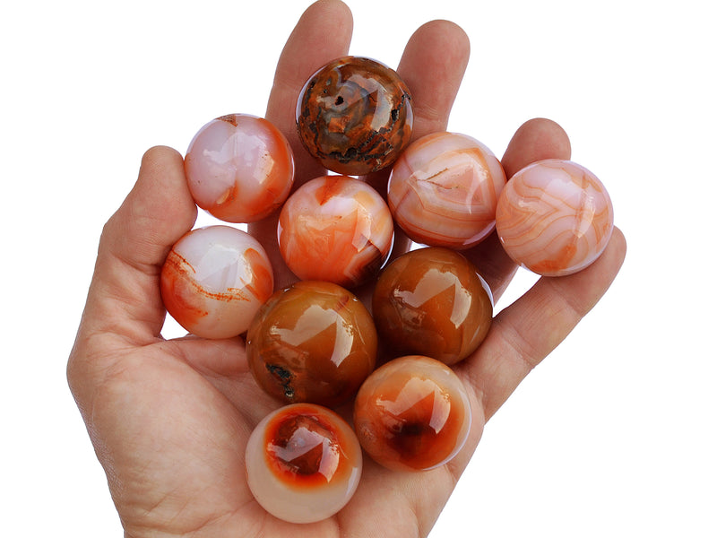 Some carnelian spheres 25mm-30mm on hand with white background