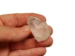 One raw clear quartz point 30mm on hand with white background