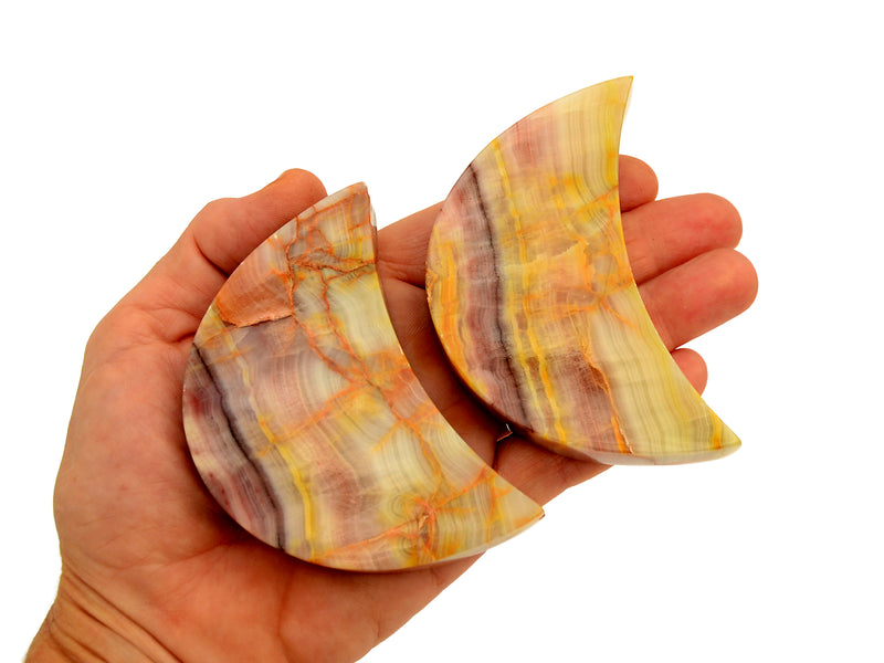 Two pink banded onyx moon stones 80mm-85mm on hand with white background