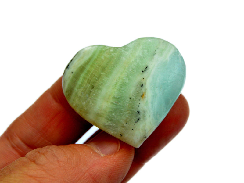 One small pistachio calcite heart 45mm on hand with white background