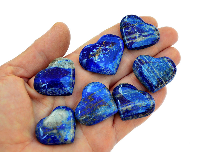 Seven lapis lazuli crystal hearts 30mm-35mm on hand with white background