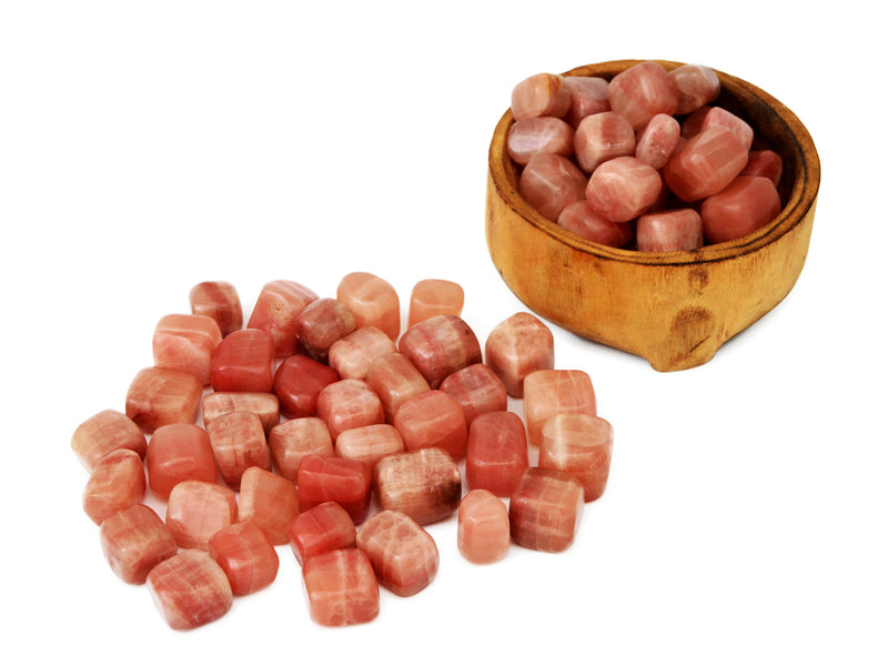 Several rose calcite mini tubledd stones inside a wood bowl and several stones outside