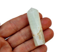 One mini blue caribbean calcite crystal point on hand 55mm with white background