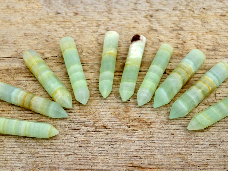 Ten pistachio calcite generator points 65mm-70mm on wood table