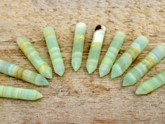 Ten pistachio calcite generator points 65mm-70mm on wood table
