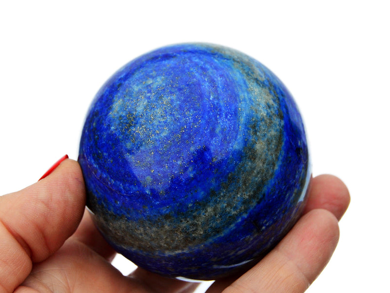 Large lapis lazuli crystal ball 85mm on hand with white background