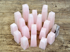 Several mangano calcite obelisks 60mm-95mm on wood table