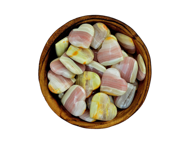 Several pink banded onyx crystal hearts 25mm-30mm inside a wood bowl on white background