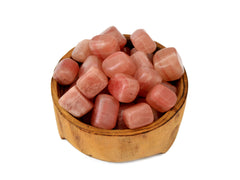 Several rose calcite tumbled crystals inside a wood bowl 