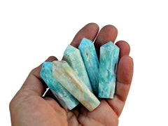 Five blue aragonite crystal points 45mm on hand with white background