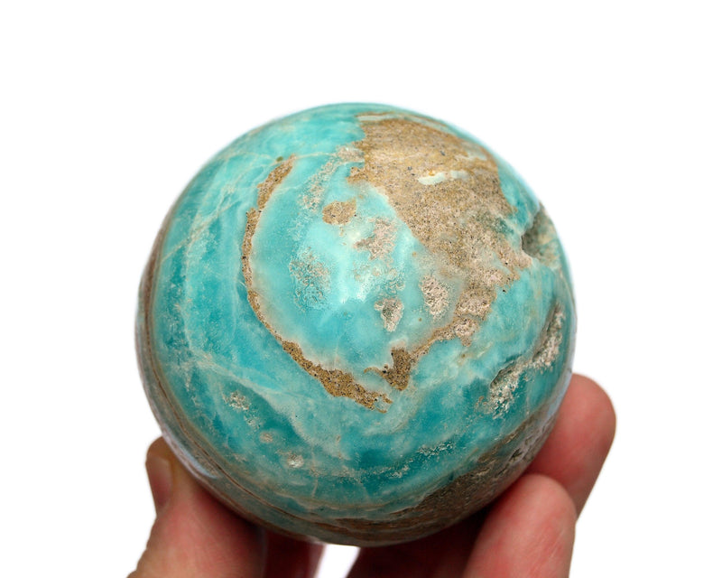 One blue aragonite sphere crystal 70mm on hand with white background