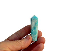 One blue aragonite faceted crystal point 45mm on hand with white background