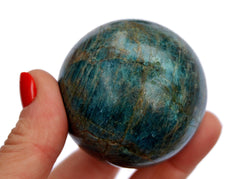 One blue apatite sphere stone 60mm on hand with white background