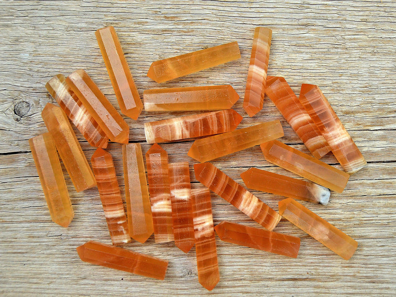 Several small honey calcite crystal points 55mm on wood table